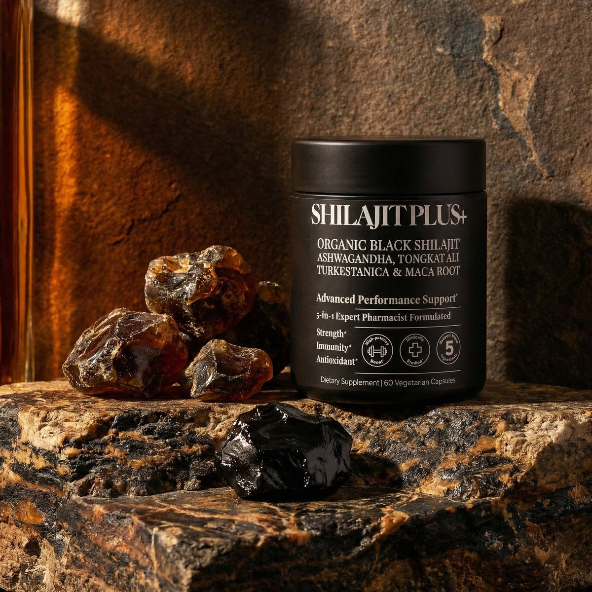 SHILAJITPLUS+ supplement on ancient dark stone surface with raw shilajit mineral resin and amber lighting