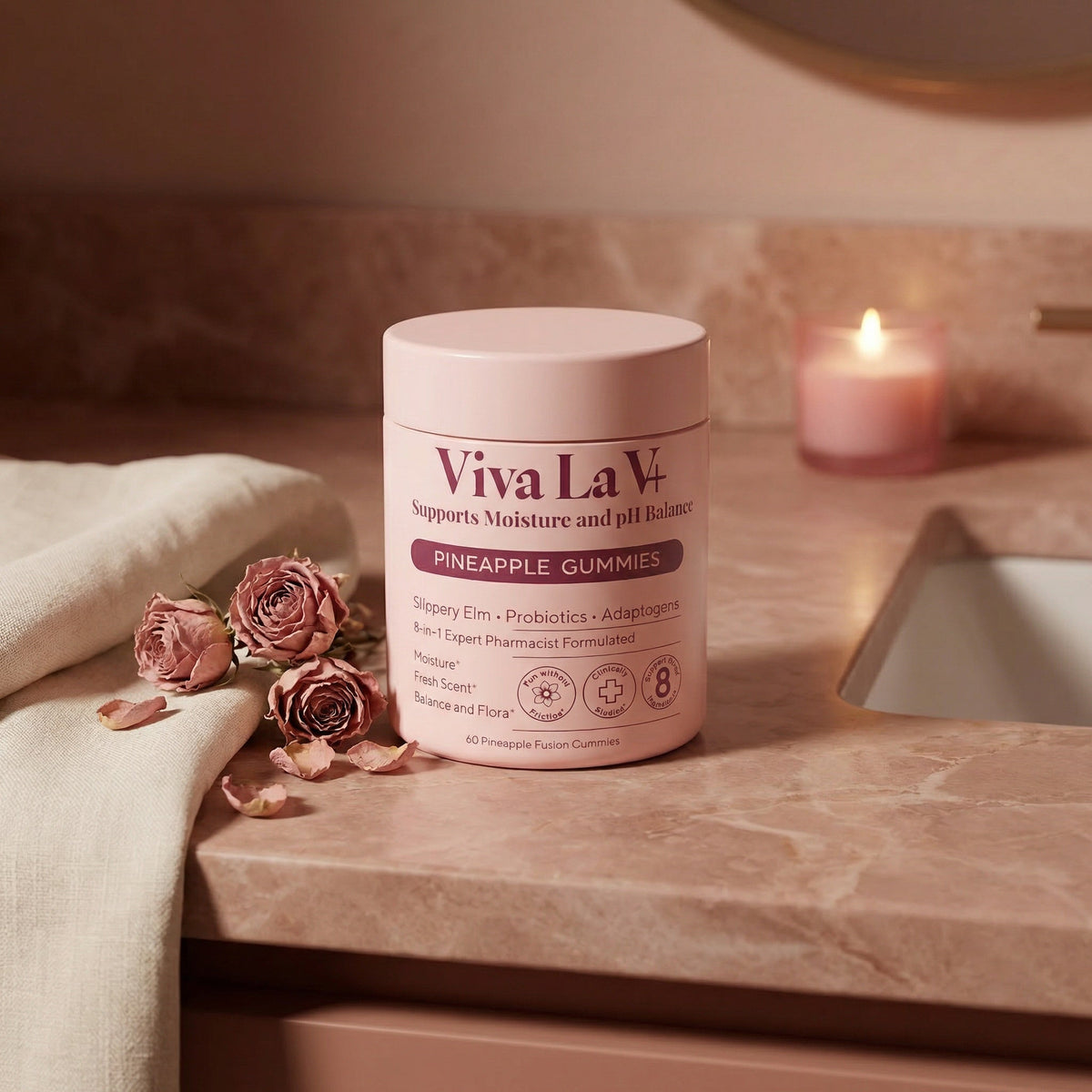 Viva La V gummies on blush stone surface with rose petals and warm light