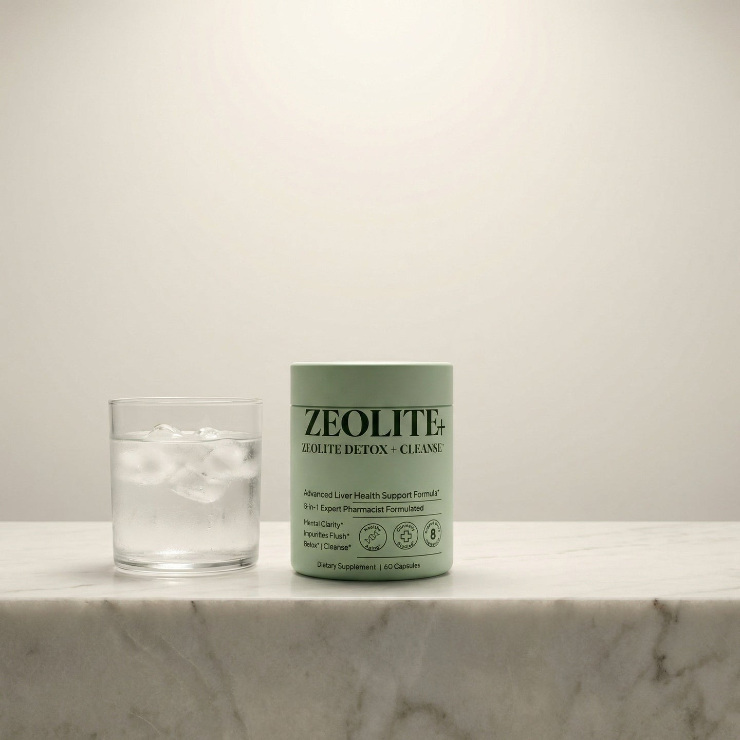 Zeolite detox supplement on white marble with a single glass of iced water
