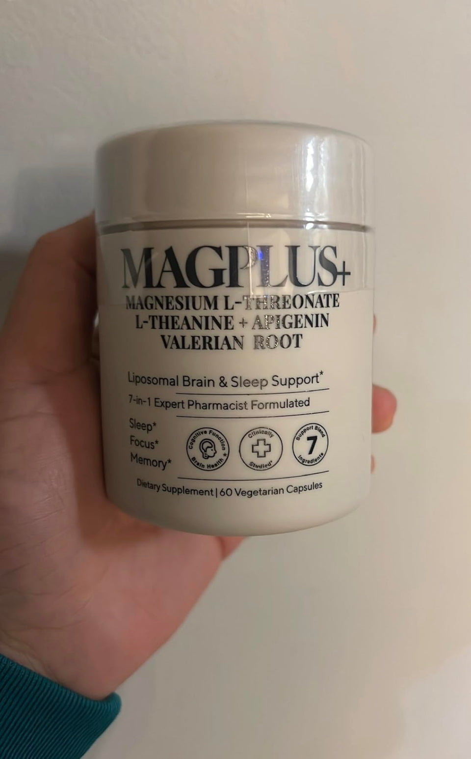 Customer holding a MAGPLUS+ 7-in-1 jar against a light wall.