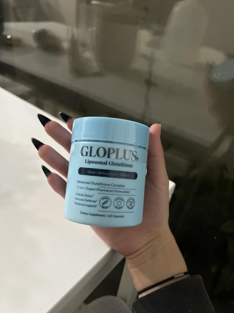 Customer holding a blue GLOPLUS+ jar above a light counter.